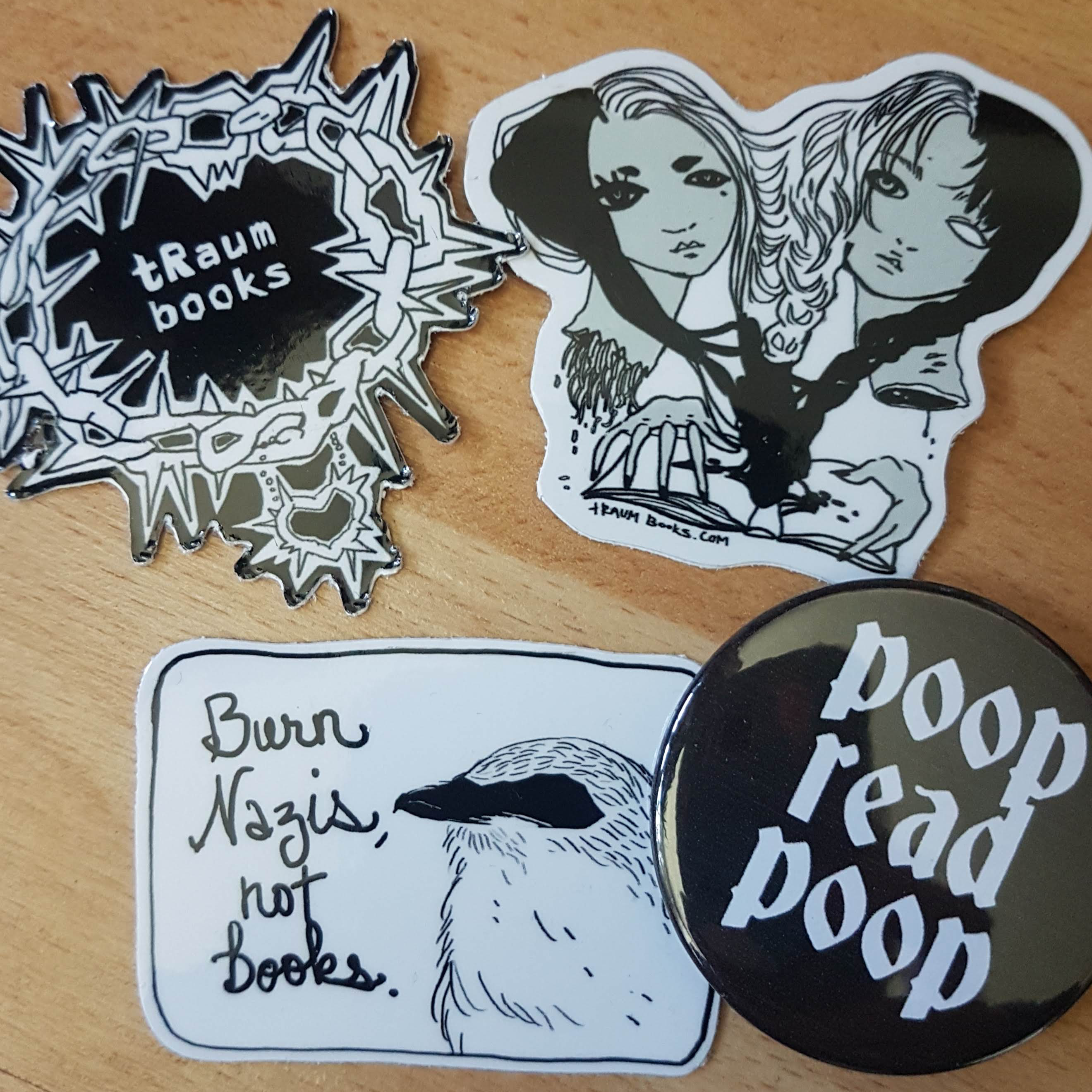 merchh an assortment of tRaum Books merch: stickers and a pin