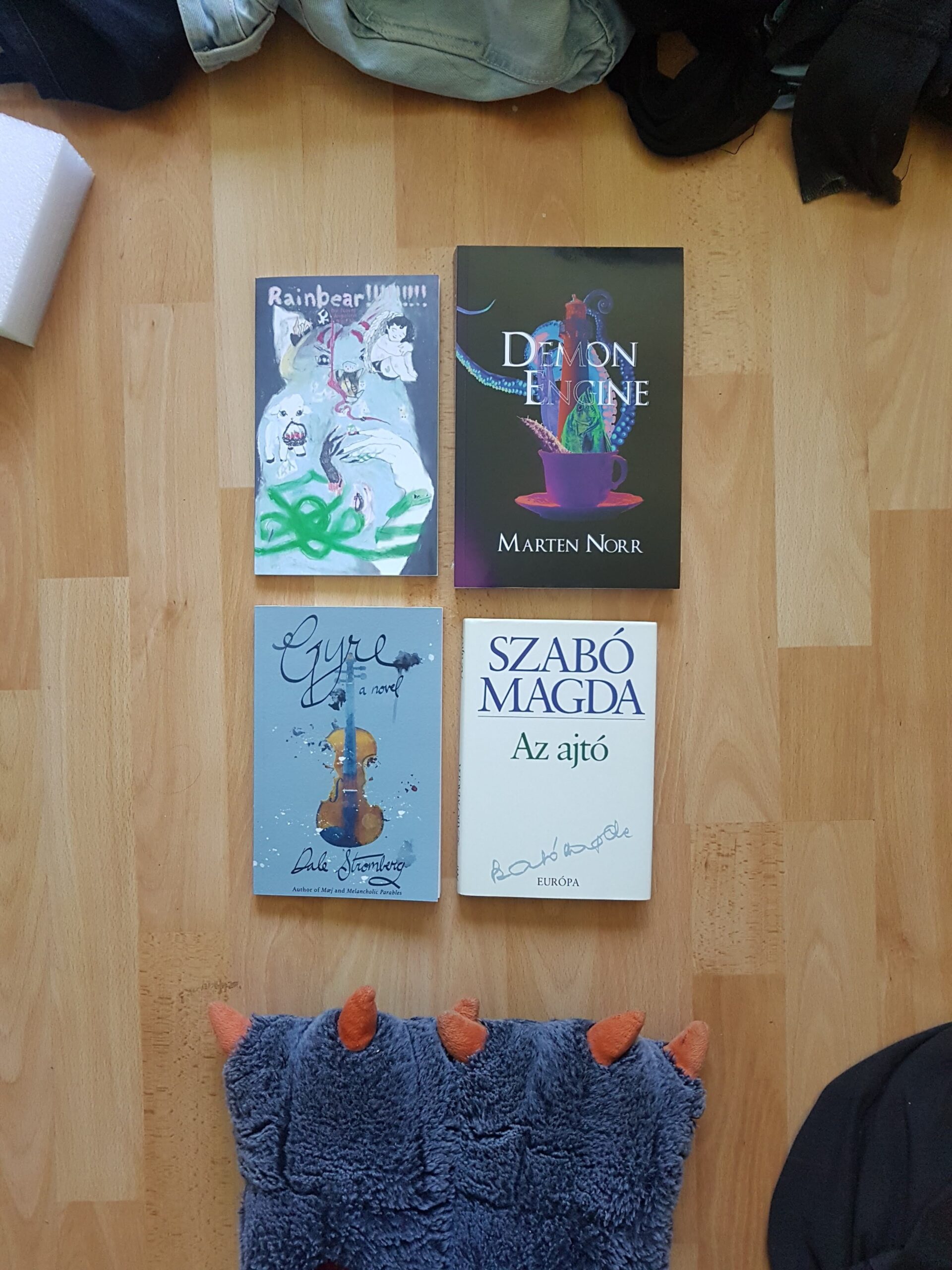 some dope reads Four books lying flat on a hardwood floor.